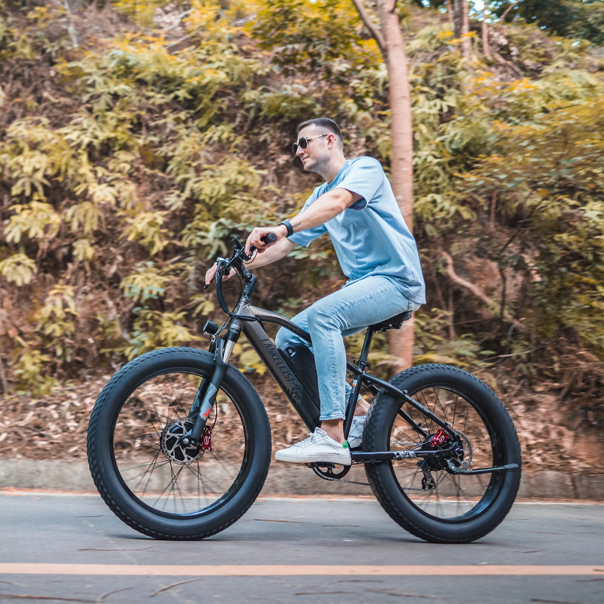 LANKELEISI MG740PLUS e-bike in forest setting, showing the sleek frame, off-road tires, and handlebar with display panel.